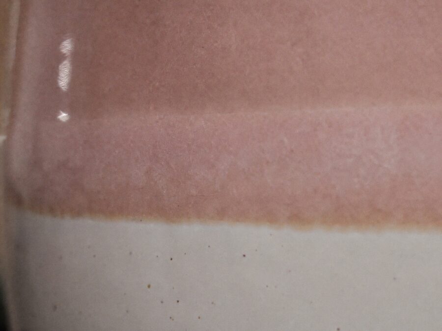 Primer plano de la unión entre el esmalte rosa y la base blanca moteada