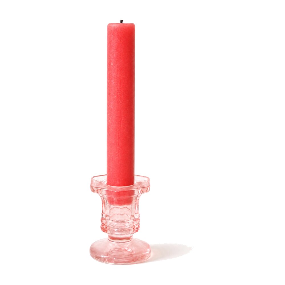 La vela roja en su candelabro de cristal rosa sobre fondo blanco