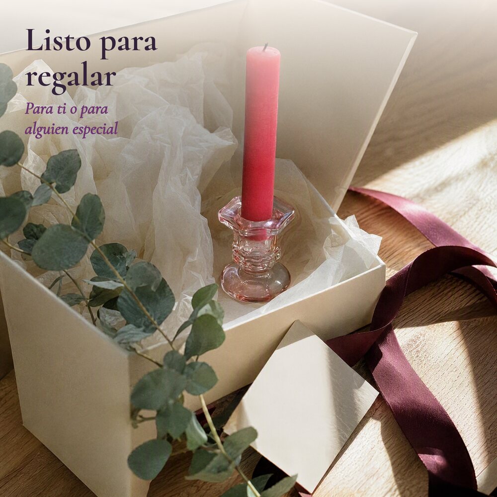 La vela en una caja de regalo con papel de seda y cinta